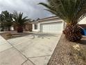Street view showcasing a single-story home, concrete driveway, desert landscaping, and mature palm trees at 7062 Russell Ranch Ave, Las Vegas, NV 89113