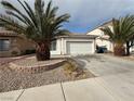 Single-story home featuring a two-car garage, desert landscaping, rock beds, and mature palm trees at 7062 Russell Ranch Ave, Las Vegas, NV 89113