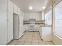 Bright kitchen featuring white cabinets, granite countertops, white appliances, and tile flooring at 7176 Fenway Ave, Las Vegas, NV 89147
