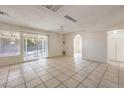 Open living room with tile flooring, sliding glass doors and views to a side entrance and outdoor space at 7176 Fenway Ave, Las Vegas, NV 89147