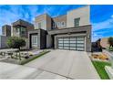 Stylish modern home exterior featuring a gray color palette, glass garage door, and desert landscaping at 746 Horizon Canyon Dr, Henderson, NV 89052