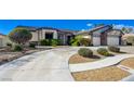Single story home featuring a circular driveway, lush shrubs, and desert landscaping at 7461 Tahoe Basin Dr, Las Vegas, NV 89129