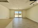 Open living area with neutral walls and wood laminate flooring leading to a backyard patio at 8072 Hackberry Dr, Las Vegas, NV 89123