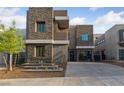 Contemporary two-story home featuring stacked stone accents, desert landscaping and a private two-car garage at 845 Loch Katrine Ave, Henderson, NV 89012