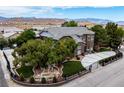 Beautiful exterior view of home with lush landscaping, water feature, mature trees and mountain backdrop at 8690 W Ford Ave, Las Vegas, NV 89148