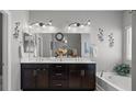 Well-lit bathroom featuring double sinks, vanity, and a soaking tub for relaxation at 9113 Sea Mink Ave, Las Vegas, NV 89149