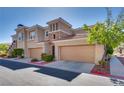 Stylish townhome featuring stone facade, well maintained landscaping, and attached two-car garage at 10809 Garden Mist Dr # 2050, Las Vegas, NV 89135