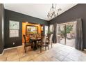 Dining room area with large windows, chandelier, and tile flooring, perfect for Gathering meals at 115 Cora Hills Ct, Las Vegas, NV 89148