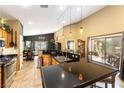 Bright kitchen with granite countertops, wooden cabinets, and pendant lights over a breakfast bar at 115 Cora Hills Ct, Las Vegas, NV 89148