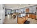 Open concept kitchen and dining area with tile floors, stainless steel appliances, an island and access to backyard at 1152 Pine Cove Ct, Henderson, NV 89011