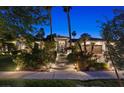 Night view of an elegant home with lush landscaping, palm trees, and a walkway leading to the front entrance at 2355 Villandry Ct, Henderson, NV 89074