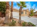Attractive exterior showing desert landscaping, long driveway and two-car garage at 2622 Rimpacific Cir, Las Vegas, NV 89146