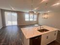 Modern kitchen island with marble countertop and sink overlooks the living space at 3481 Bradano Ln, Henderson, NV 89044