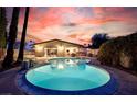 Inviting backyard pool with a unique kidney shape perfect for relaxation and entertaining during sunset at 3597 Cochise Ln, Las Vegas, NV 89169