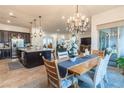Open-concept dining room with chandelier, wood table, and access to the kitchen with a large island at 408 Middlestone Ave, Henderson, NV 89011