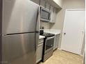 Modern kitchen with stainless steel appliances, light gray cabinets, and tile flooring at 45 Maleena Mesa St # 1113, Henderson, NV 89074