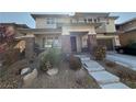 Inviting two-story home with a covered porch, stone accents, and an attached two-car garage at 5615 Oak Bend Dr, Las Vegas, NV 89135