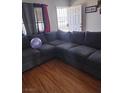 Comfortable living room featuring a large sectional sofa and wood-look flooring at 609 Marcella Ave, North Las Vegas, NV 89030