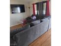 Spacious living area showcasing a plush sofa, TV, and hardwood floors at 609 Marcella Ave, North Las Vegas, NV 89030