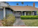 Inviting front entrance with brick pathway, trimmed hedges and double doors at 6304 Peppermill Dr, Las Vegas, NV 89146