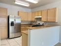 Bright kitchen with stainless steel refrigerator, granite countertops, and light wood cabinetry at 7450 S Eastern Ave # 1059, Las Vegas, NV 89123