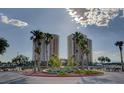 Exterior shot features roundabout with well manicured foliage and palm trees leading up to the modern condo buildings at 8255 Las Vegas Blvd # 1315, Las Vegas, NV 89123