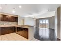 Open kitchen and living area with stainless steel appliances, granite countertops, and hardwood floors at 8255 Las Vegas Blvd # 1315, Las Vegas, NV 89123