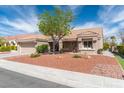 Inviting single-story home with desert landscaping, mature tree, and a covered front porch at 8812 Marble Dr, Las Vegas, NV 89134