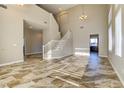 Open-concept living area boasts tall ceilings, tile flooring, and a staircase leading to the upper level at 8944 Campanella St, Las Vegas, NV 89123