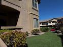 Exterior condo view featuring green grass and shrubbery near a beige building at 8985 S Durango Dr # 1010, Las Vegas, NV 89113
