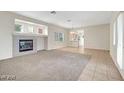 Bright living room with a cozy fireplace, neutral paint and carpeting, and tons of natural light at , Las Vegas, NV 89144