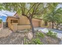 Charming home featuring a tile roof, tan stucco, a two-car garage, and a low-maintenance front yard at 11913 Alava Ave, Las Vegas, NV 89138