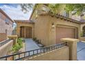Charming home featuring a tile roof, tan stucco, a two-car garage, and a landscaped front yard at 11913 Alava Ave, Las Vegas, NV 89138