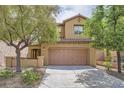 Inviting two-story home featuring a tile roof, tan stucco, a two-car garage, and mature trees at 11913 Alava Ave, Las Vegas, NV 89138