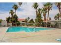 Sparkling community pool surrounded by palm trees, lounge chairs, and a covered seating area at 2725 S Nellis Blvd # 2083, Las Vegas, NV 89121