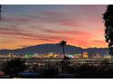 Breathtaking skyline view with colorful buildings and palm trees, set against a vibrant sunset at 6861 E Washington Ave, Las Vegas, NV 89110