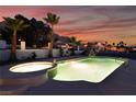 Resort-style pool and spa area featuring lush tropical landscaping and mountain views at sunset at 6861 E Washington Ave, Las Vegas, NV 89110