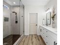 Bright bathroom featuring a glass-enclosed shower and double vanity with white cabinets at 8276 Aurora Peak Ave, Las Vegas, NV 89131