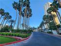 Long driveway lined with many tall palm trees leads to a beautiful building with a covered entrance at 135 E Harmon Ave # 3320, Las Vegas, NV 89109