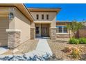 Inviting home entrance featuring stone accents, desert landscaping, and a well-lit walkway at 3908 Specula Wing Dr, North Las Vegas, NV 89084