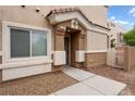 Charming home entrance featuring neutral tones, a window, and landscaped gravel pathway at 6045 Riverwalk Falls St # 102, North Las Vegas, NV 89031