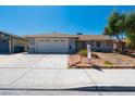 Charming single-Gathering home featuring a well-manicured front yard, a two-car garage, and a cozy, inviting entrance at 6361 W Viking Rd, Las Vegas, NV 89103