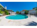 Backyard pool with a white concrete deck, patio with table and chairs, with well maintained backyard plants at 6361 W Viking Rd, Las Vegas, NV 89103