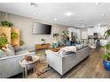 Open-concept living room with modern furnishings, a large TV, and wood-look floors at 8701 Giant Causeway Ave, Las Vegas, NV 89148