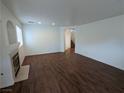 Spacious living room with wood floors, a fireplace, and an archway to the staircase at 10673 Alondra Peak St, Las Vegas, NV 89183