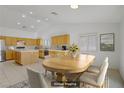 Open dining area with a wooden table set, adjacent to a bright kitchen with modern appliances at 205 Derwent Pl, Las Vegas, NV 89144
