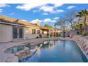 Backyard featuring a private pool, spa, covered patio, and desert landscaping at 205 Derwent Pl, Las Vegas, NV 89144