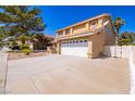 Wide driveway leading to a well-maintained two-story home with an attached two-car garage at 2105 Harbor Cliff Dr, Las Vegas, NV 89128