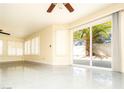 Bright living room featuring tile floors, a ceiling fan, and sliding glass doors to the patio at 2105 Harbor Cliff Dr, Las Vegas, NV 89128