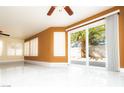 Bright living room featuring white tile flooring, shuttered windows, and a sliding glass door at 2105 Harbor Cliff Dr, Las Vegas, NV 89128